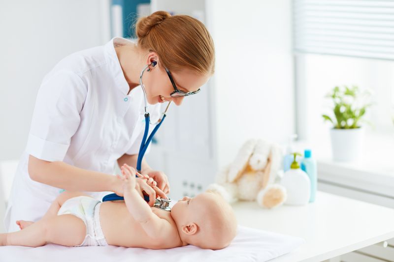 Zdravotní sestra vyšetřuje dítě fonendoskopem